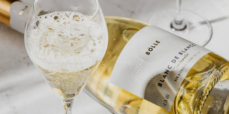 BOLLE Blanc de Blancs non-alcoholic sparkling wine poured into a glass beside the bottle