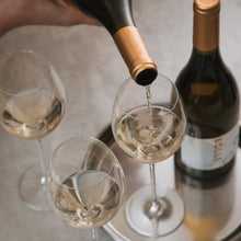 Pouring BOLLE Chardonnay non-alcoholic white wine into glass overhead view, best alcohol-free wine for entertaining